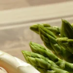 Weißer und grüner Spargel auf einem Holzbrett, mit frischen, knackigen Spitzen.