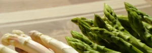 Weißer und grüner Spargel auf einem Holzbrett, mit frischen, knackigen Spitzen.